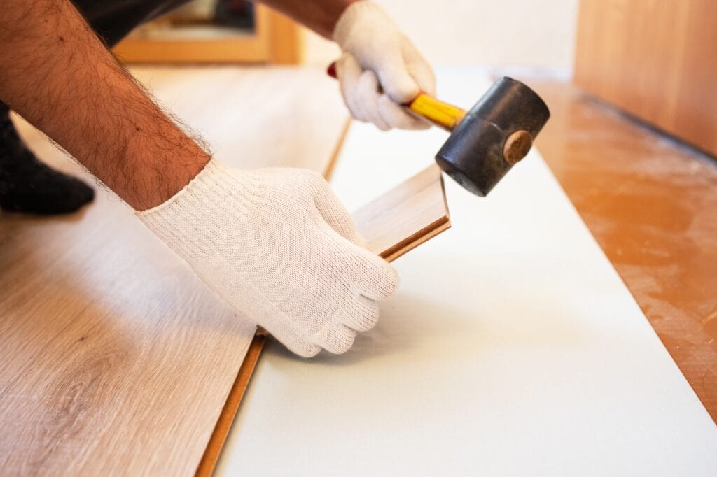 A carpenter lays the floor, there is no face in the house