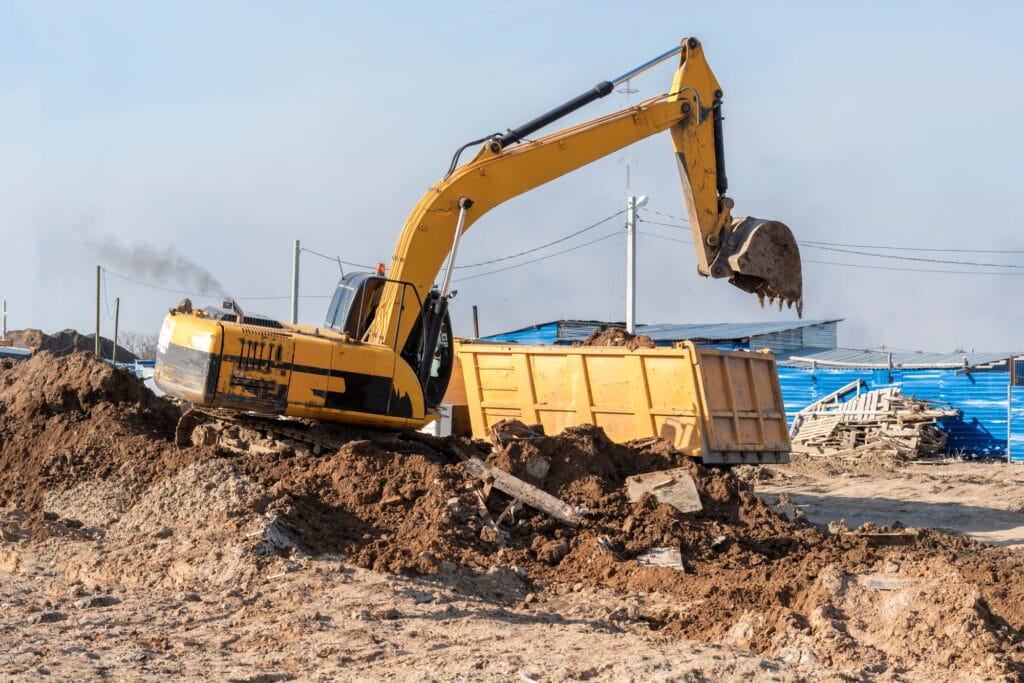 a excavator bulldozer digging dirt ground, shoveling ion the construction site