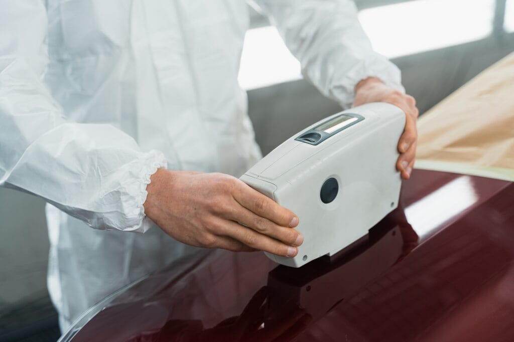 Close-up view of a auto painter determining the exact shade of a car's color