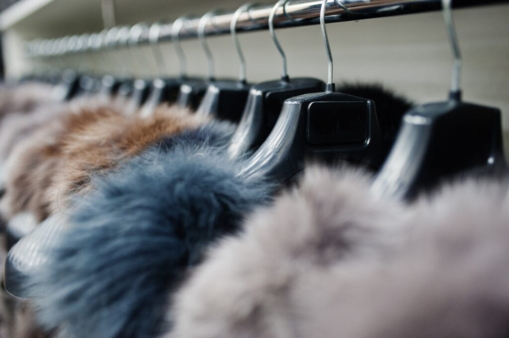 Clothes hang on a shelf in a designer fur clothes store.