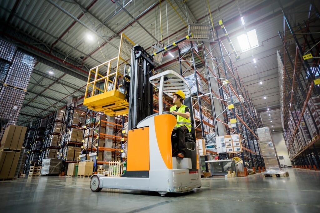 Forklift operator during work in large warehouse