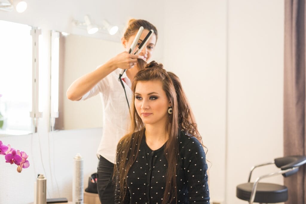 Hairdresser doing haircut for women in hairdressing salon