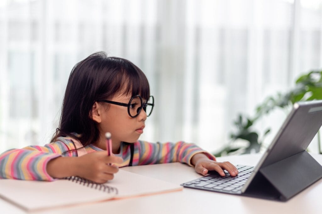 Happy girl learn english language online with tablet at home.