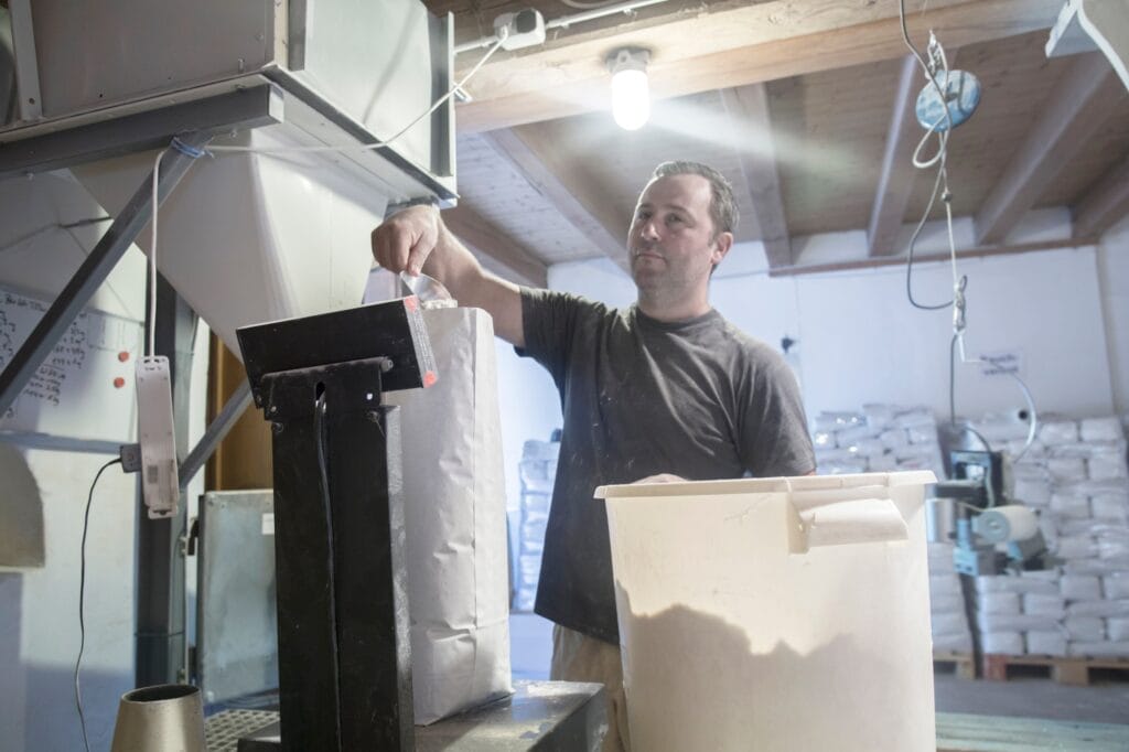 Male miller filling sacks with milled flour in wheat mill