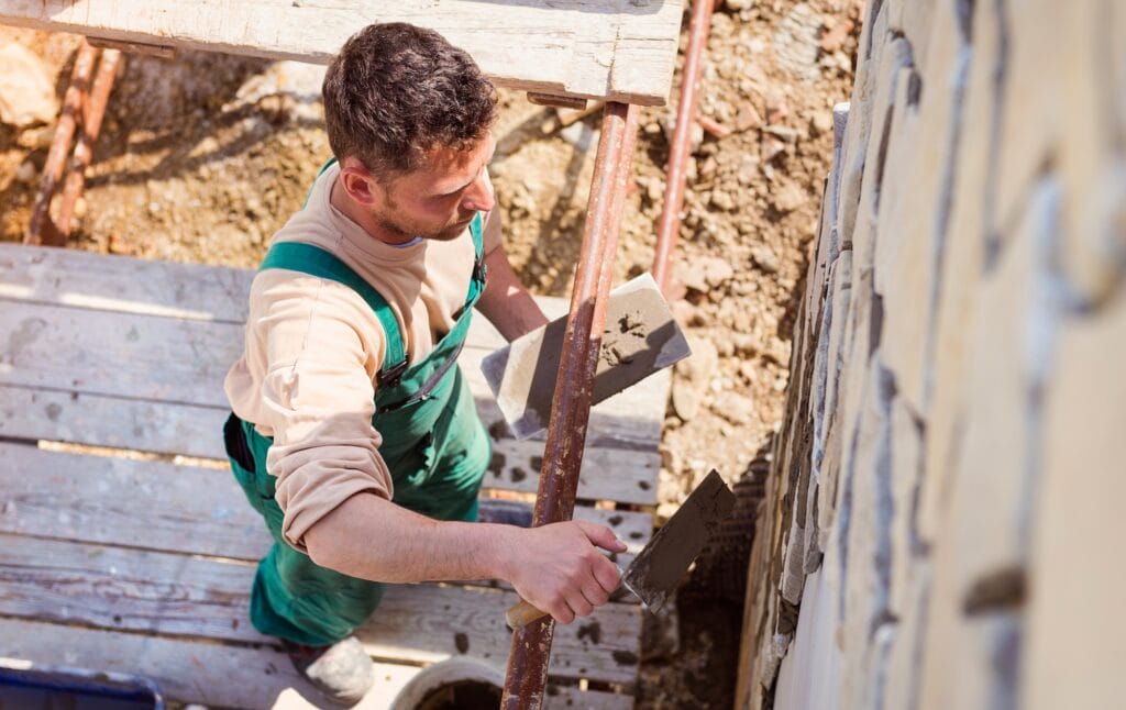 Man putting natural stones on a wall