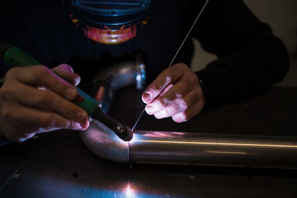 Man working with argon welding machine in a garage