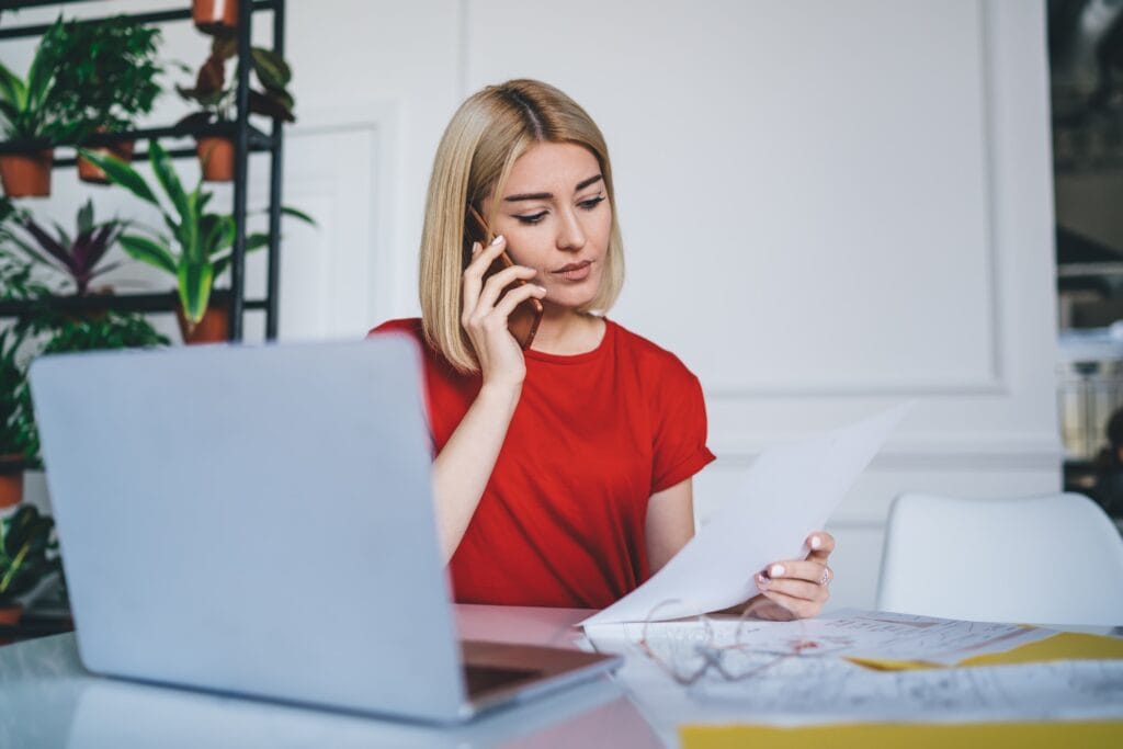 Manager reading document and talking on smartphone
