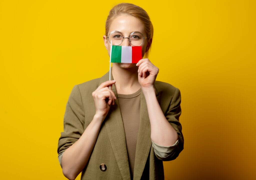 Style blonde woman in jacket with Italian flag on yellow background