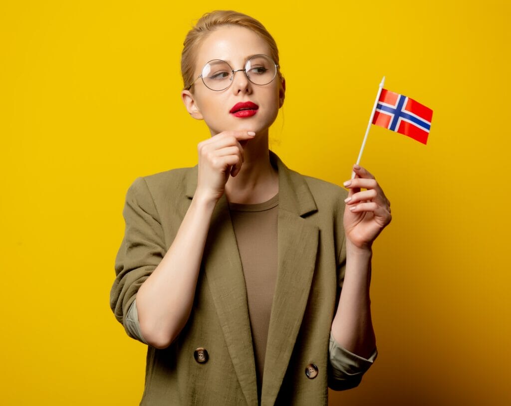 Style blonde woman in jacket with Norwegian flag on yellow background