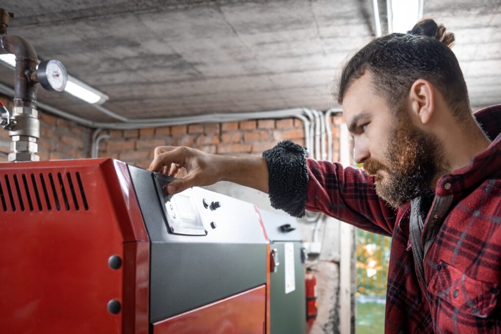 The man with solid fuel boiler, working with biofuels, economical heating.
