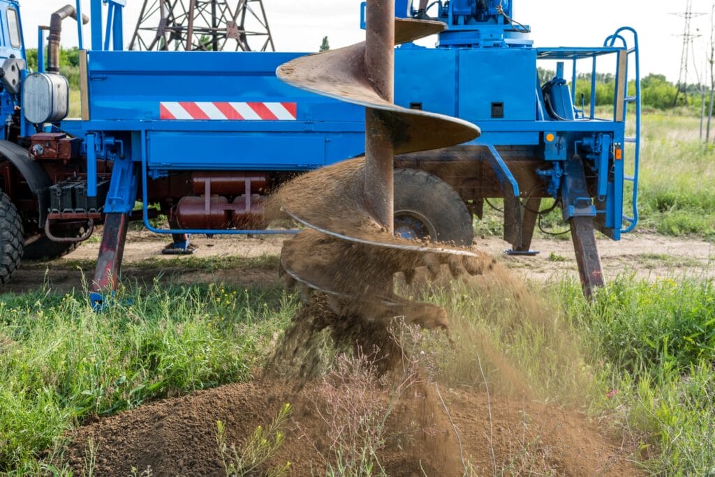 Tracer tractor with auger for soil drilling for piles