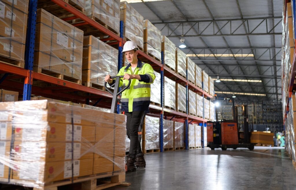 Worker in auto parts warehouse use a handcart to work to bring the box of auto parts